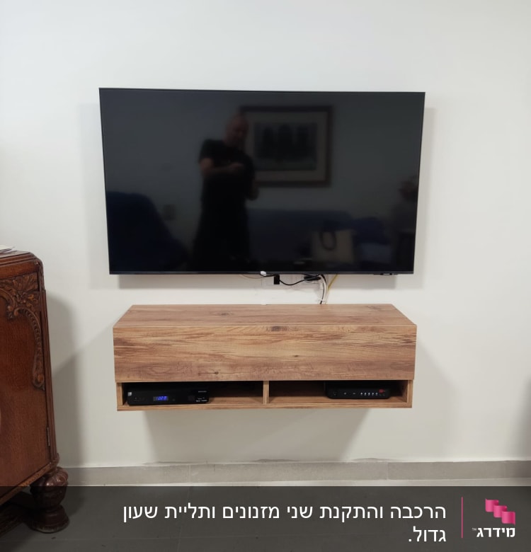 טלוויזיה תלויה על קיר עם כבלים חשופים